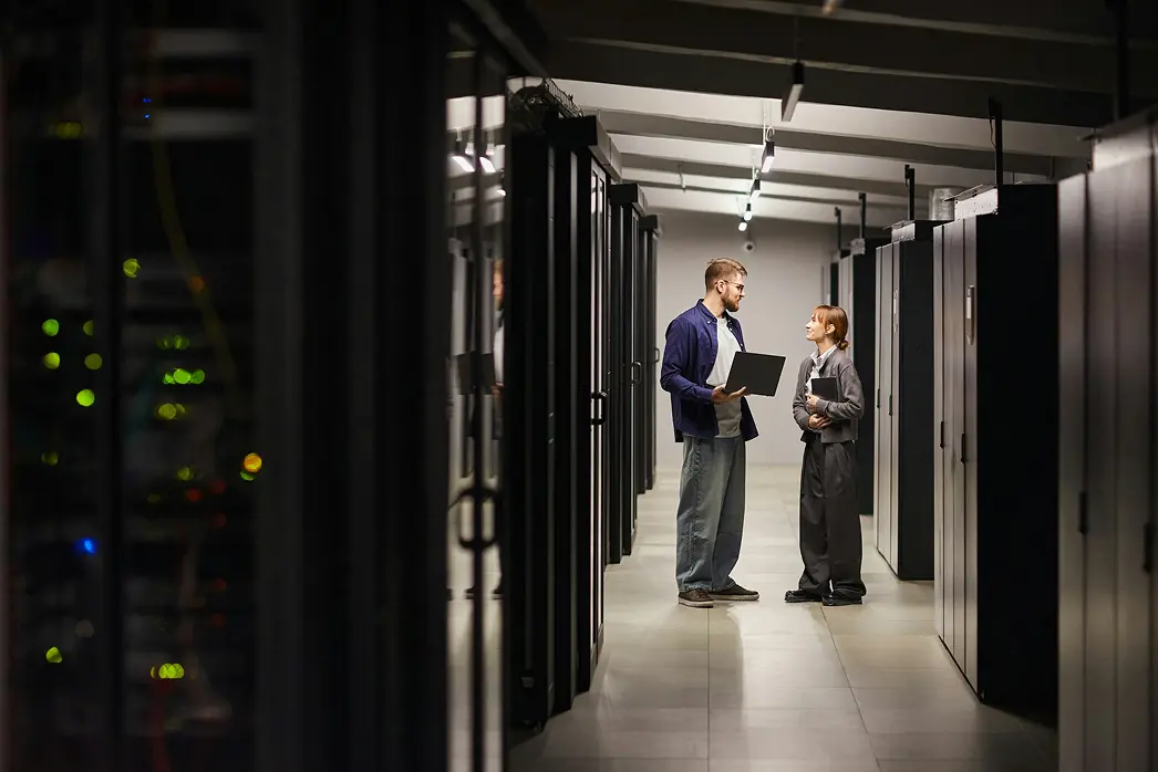 Two engineers reviewing a target company's infrastructure in a server hallway